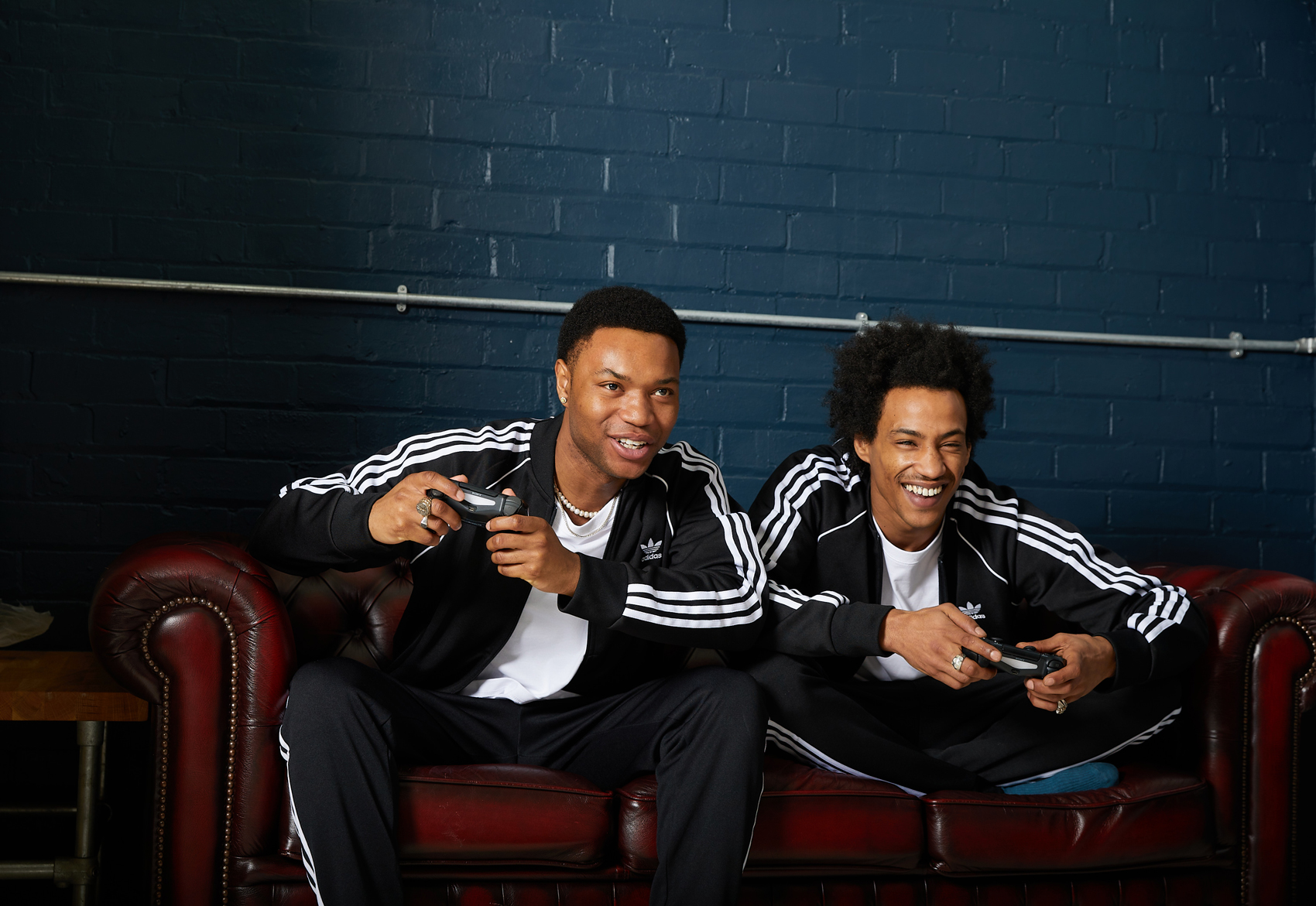 2 guys play playstaton in Adidas 