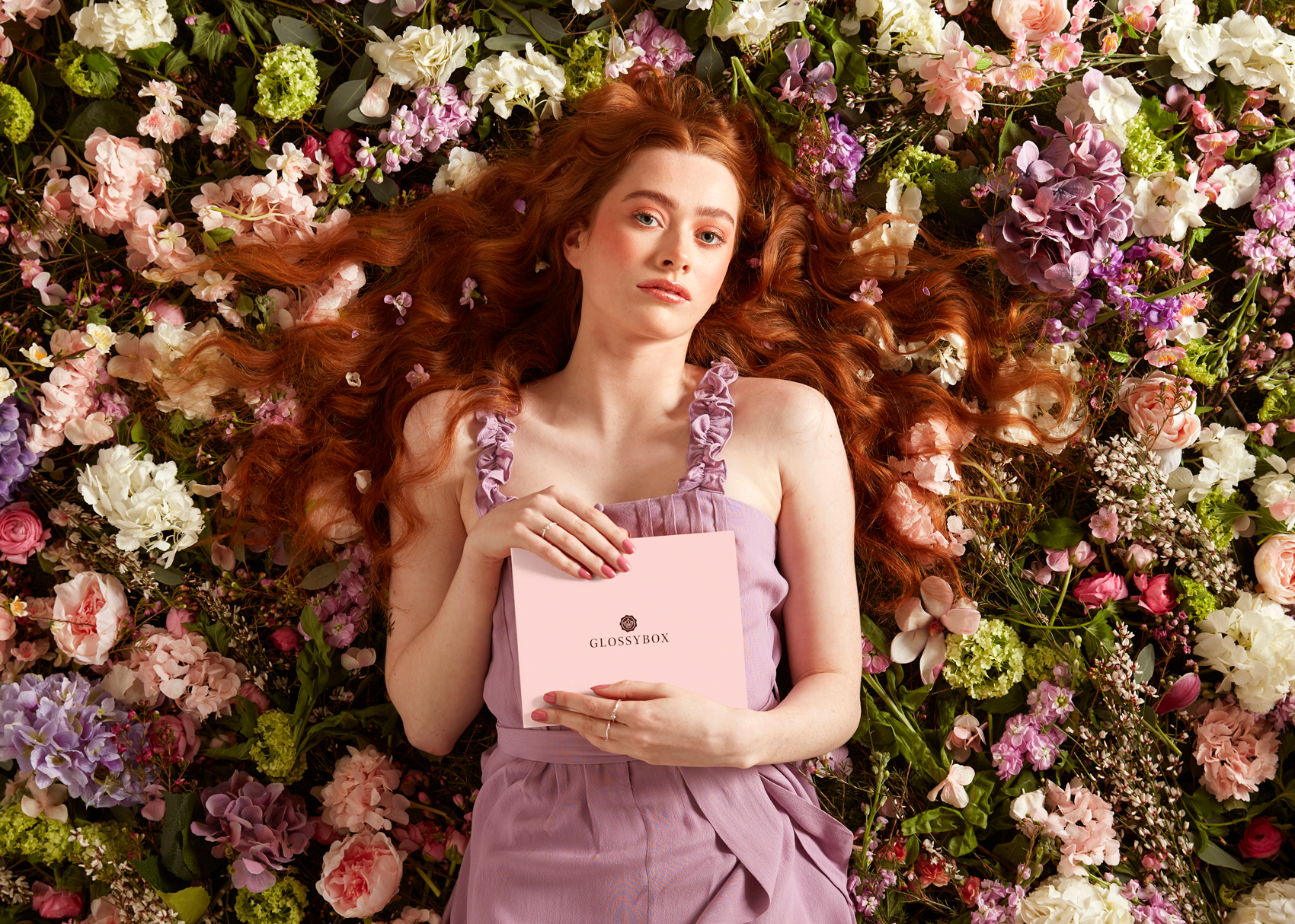 Model lying in bed of flowers photography